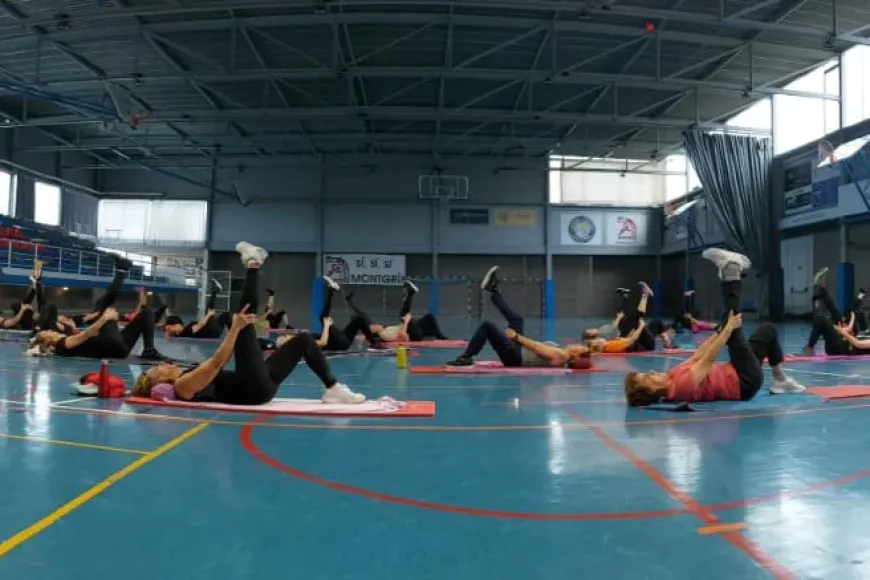 Grup de persones estirades al terra fent exercici físic.
