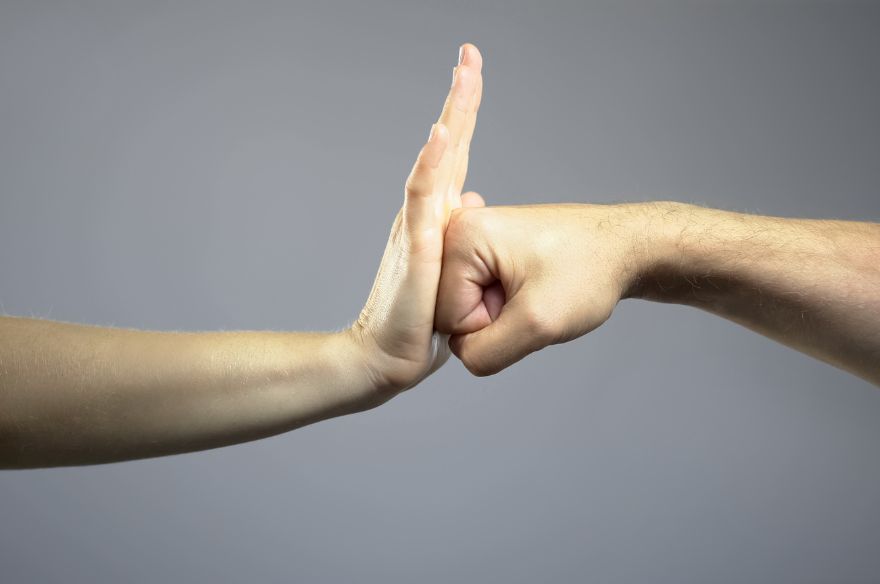 Una mà aturant un cop de puny