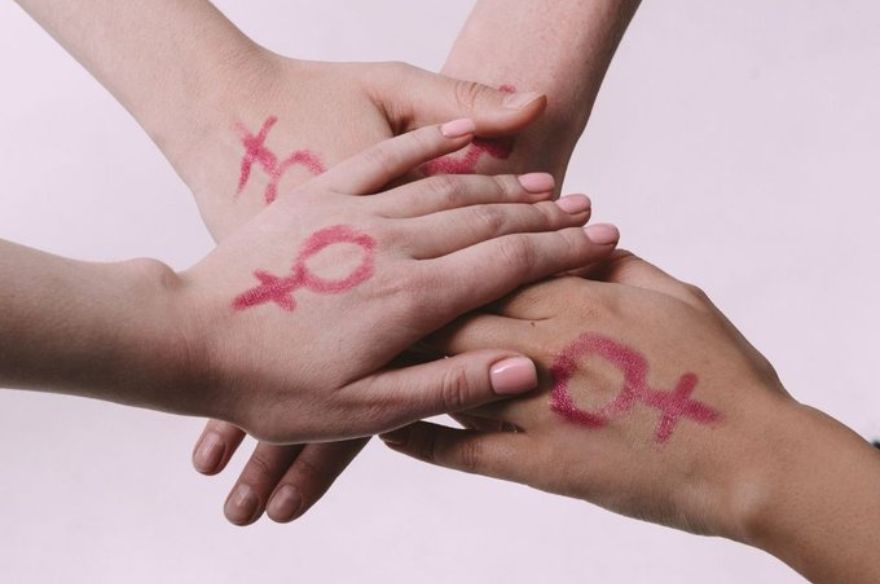 Unes mans unides amb el signe del feminisme pintat