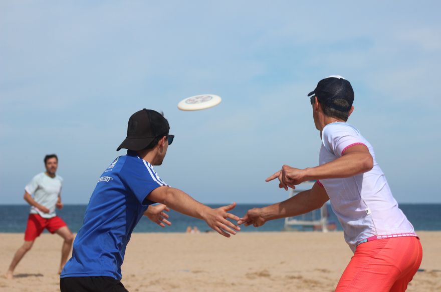 Dos nois juguen a Fresbee a la platja