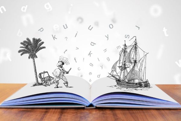 Un llibre obert amb una palmera i un vaixell, significant la màgia dels contes