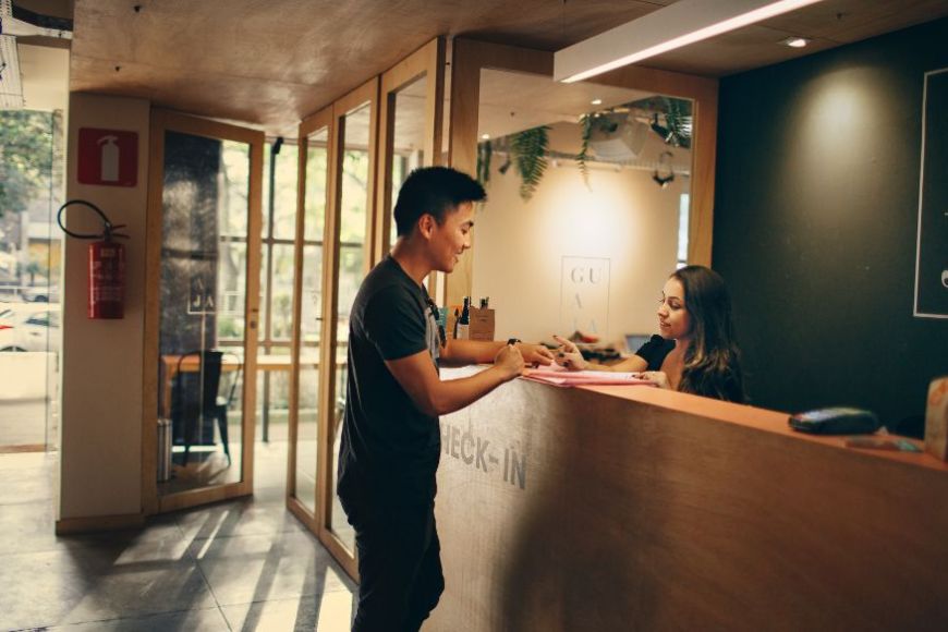 Una recepcionista atenent un client en un hotel Una recepcionista atenent un client en un hotel