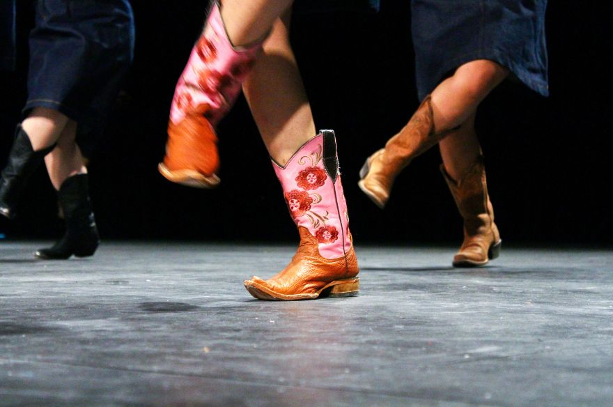 Unes cames amb botes de cowboy ballant country