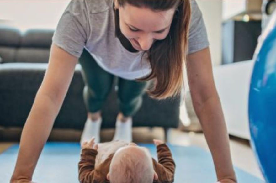 Una mare fent exercicis de recuperació post-part amb el seu nadó