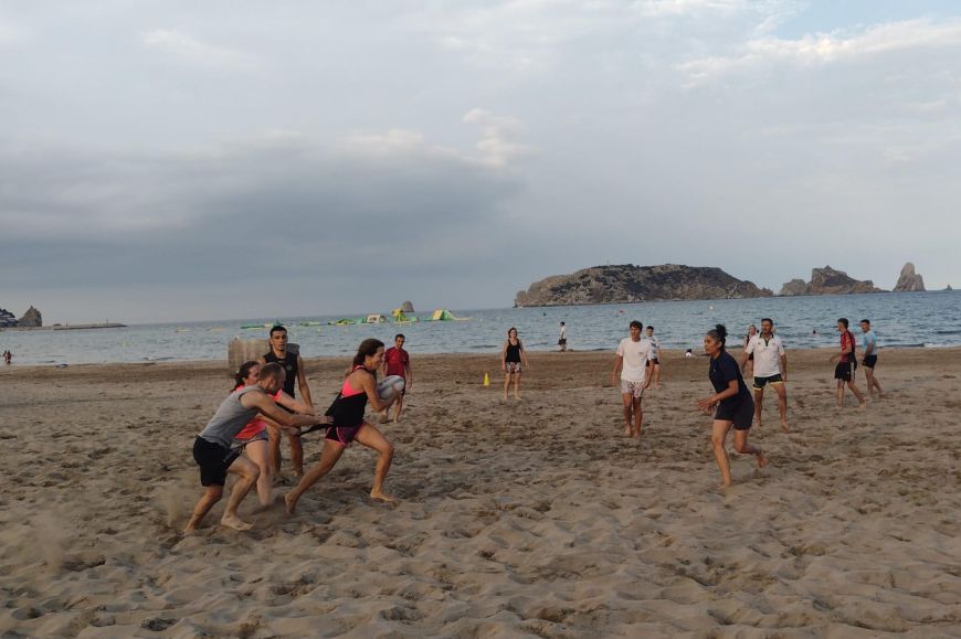 Grup de rugby a la platja de l'Estartit Un grup de persones juga a rugby a la platja de l'Estartit amb les illes Medes de fons.